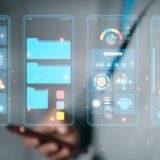 Person interacting with virtual mobile app interface prototypes displaying charts, graphs, and UI elements for app development.